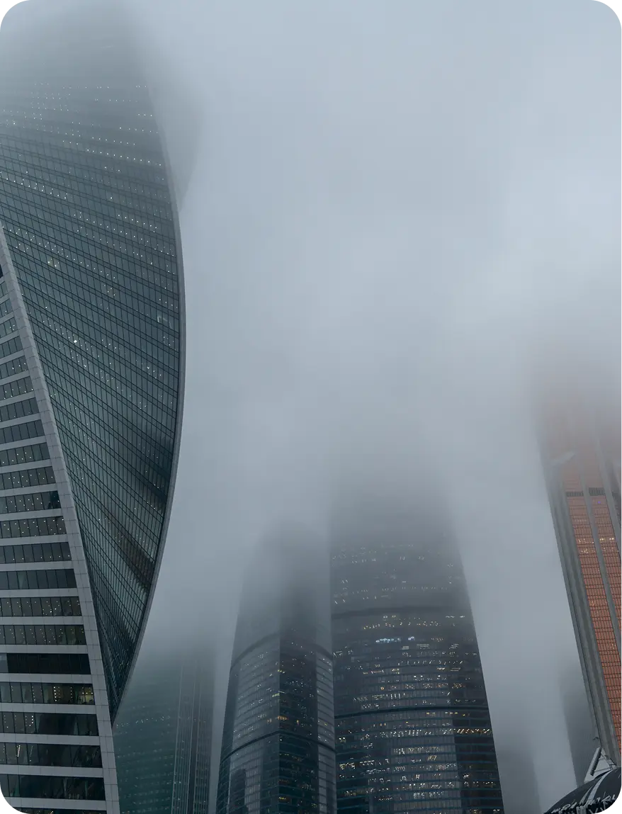 Photo of skyscrapers partially obscured by fog, illustrating perpetual crisis